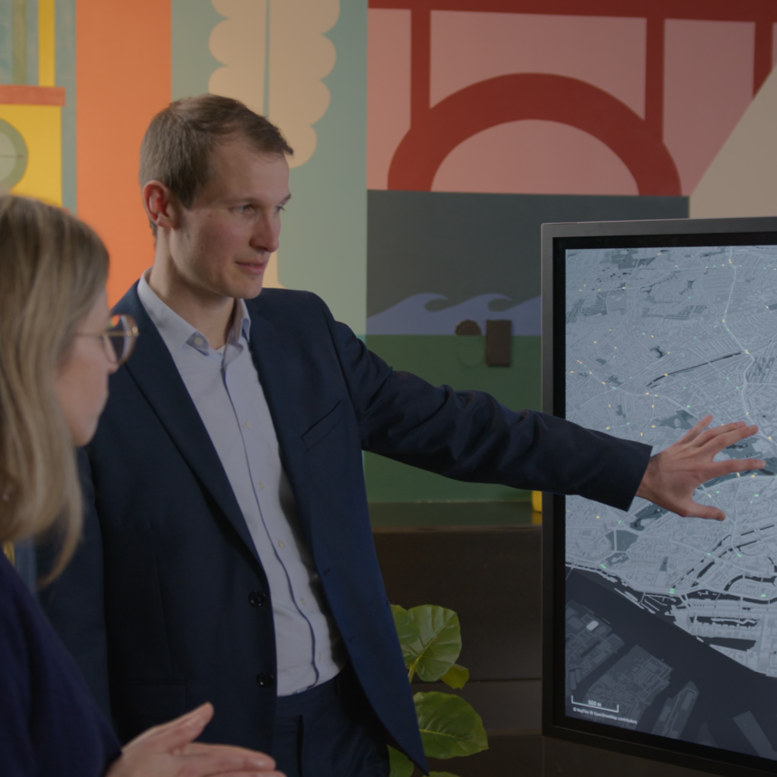 a MOIA consultant points at the Mobility Impact Analyzer simulation 